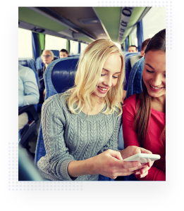 Two girls smiling at an iPhone on a bus ride